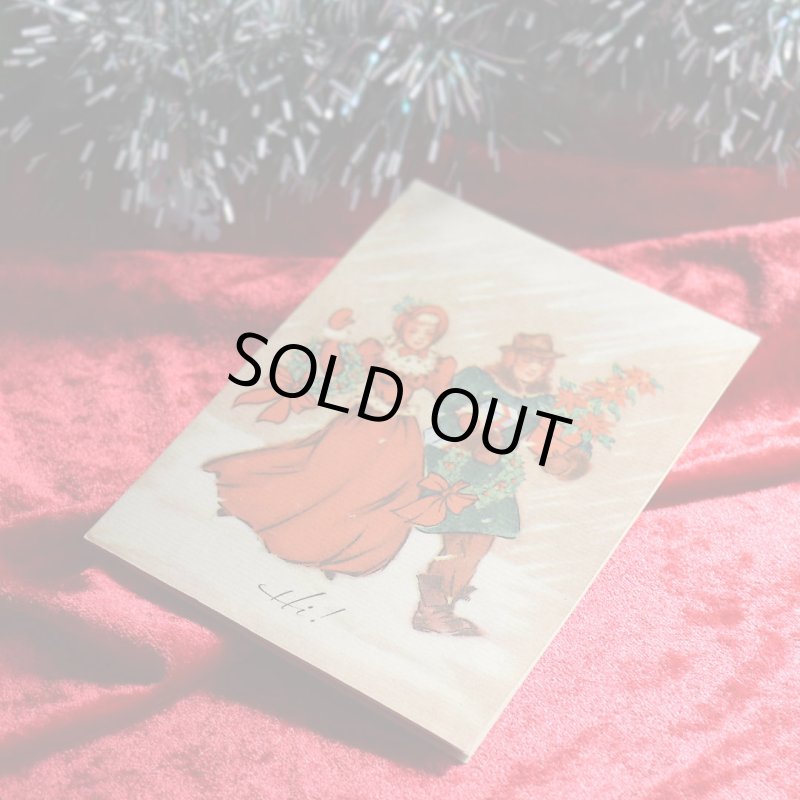 アンティーククリスマスカード|ポインセチアとクリスマスリースを抱える男女アンティークカード