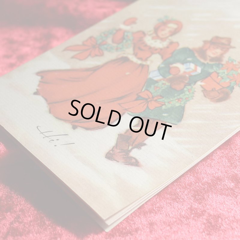 アンティーククリスマスカード|ポインセチアとクリスマスリースを抱える男女アンティークカード