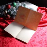 アンティーククリスマスカード｜ポインセチアとクリスマスリースを抱える男女アンティークカード